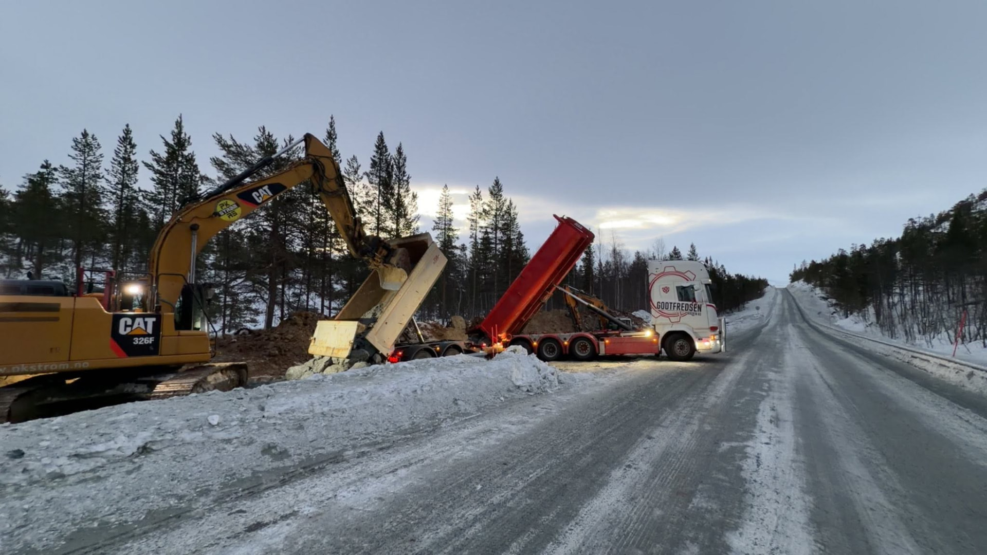 Godtfredsen Maskin AS på veianlegg om vinteren med gravemaskin og rød dumper
